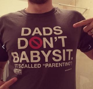 Man in t-shirt which bears a slogan: "Dads don't babysit. It's called parenting."