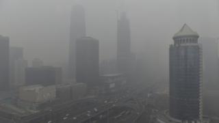 Vehicles travel on the Guomao bridge (bottom L) as the Central Business District (CBD) area is seen amid heavy smog after the city issued its first ever "red alert" for air pollution, in Beijing, China, December 8, 2015