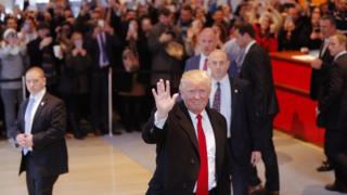 US President elect Donald Trump reacts to a crowd gathered in the lobby of the New York Times building after a meeting in New York, U.S., November 22, 2016