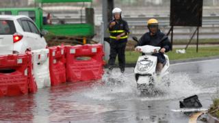 澳門一名男子騎著摩托車開過略有積水的馬路(27/8/2017)