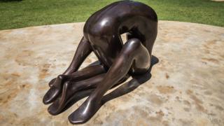 One of three untitled bronze sculptures by Edgar de Souza that represent a nude male figure based on the artist's own body, but without a face.