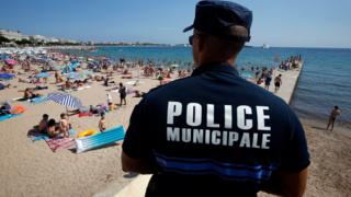 A French police officer patrols the beach in Cannes on 4 August 2016