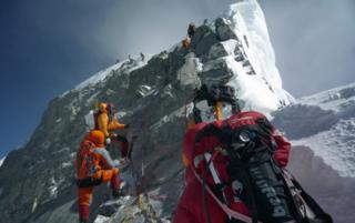 Unidentified mountaineers walk past the Hillary Step while pushing for the summit of Everest on May 19, 2009