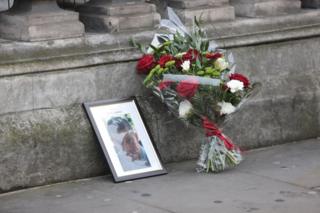 Una fotografía y un ramo de flores recuerda que el policía Keith Palmer murió en el ataque ocurrido este miércoles ante el Parlamento británico, en Londres.