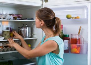 Mujer con la refrigeradora abierta