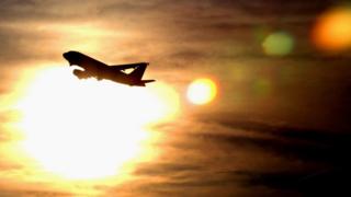 A plane is silhouetted against the sky as it takes off from Heathrow Airport 19 December 2002 in London, England.