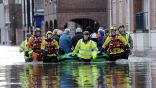 Members of the army and rescue teams help evacuate people from flooded properties after they became trapped by rising floodwater when the River Ouse bursts its banks in York city centre in December 2015