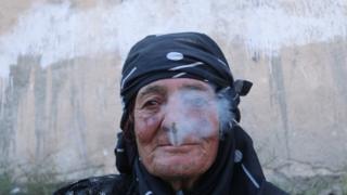 Une femme fume une cigarette, un acte qui était interdit sous l'Etat islamique.