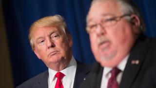 Republican presidential candidate Donald Trump (L) listens as Sam Clovis speaks in Dubuque, Iowa, on 25 August 2015