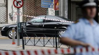 Un policía vigila la calle donde se encuentra el auto en el estaba Papademos cuando se produjo la explosión.