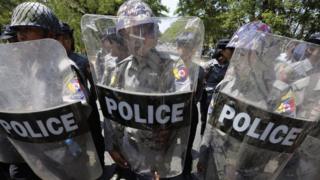Riot police officers block the road to stop protesters marching demanding labor rights in TetKone, near Naypyitaw, Myanmar, 18 May 2016.