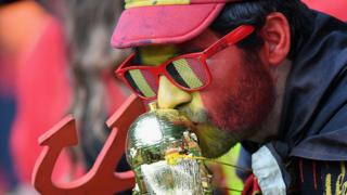 A Belgian football fan kisses a fake Jules Rimet trophy