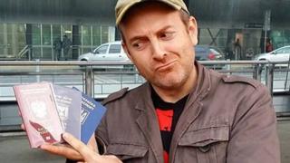 Alexander Lapshin holding his passports for Russia, Israel and Ukraine.
