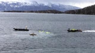 A boat picks up tourists from the water after an accident in Harstad harbour in Northern Norway.