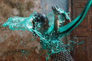 A girl reacts as coloured water is thrown on her during Holi, the Festival of Colours, in Mumbai, India, 13 March 2017.