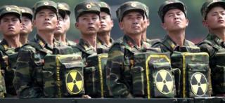 North Korean soldiers pose with packs bearing the nuclear emblem in Pyongyang (July 2013)