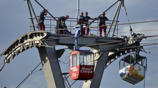 German cable car collision leaves dozens stranded in mid-air 1 Firefighters assess the damage caused after a cable car struck a pillar in Cologne, Germany, 30 July 2017
