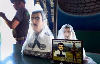 Una foto de Joaquín "el Chapo" Guzmán frente a dos figuras de Malverde en una tienda contigua a una capilla dedicada al santo en Culiacán, Sinaloa, México, el 7 de diciembre de 2016.