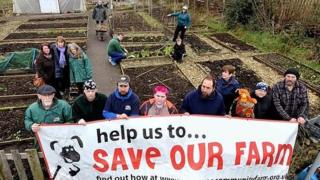 Campaigners to keep the farm open holding a banner