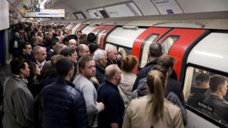 A crowded tube platform as commuters wait to board