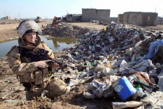 2007: A British troop in Basra patrols a rubbish-strewn area