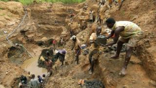 Les travailleurs forment une chaîne humaine pour relayer des seaux de boue et de pierres dans une mine d'or à Iga Barriere le 18 juin 2003, à l'est de la RD Congo (archives)