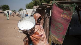 Un femme dans un camp de déplacés à la recherche d'eau.