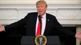 Donald Trump stretches his arms out at the White House.