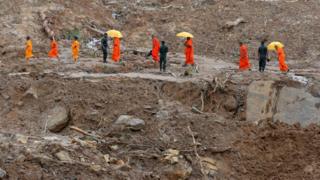 Sri Lankan Buddhist monks cross a landslide as military rescue workers and villagers search for survivors in Athweltota village in Kalutara on May 30, 2017. Sri Lanka appealed May 30 for volunteers to help with a massive clean-up after landslides and floods left at least 193 dead and tens of thousands without safe drinking water. The government sought help to purify wells contaminated by the floods, the worst in 14 years after record rainfall in the island's southwest. / AFP PHOTO / ISHARA S. KODIKARA (Photo credit should read ISHARA S. KODIKARA/AFP/Getty Images)