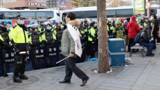 身披韩国国旗的抗议群众,不断地向警察挑衅