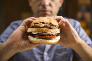 Hombre sosteniendo una hamburguesa