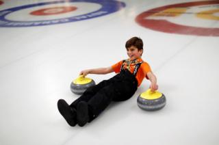 A Yazidi refugee from Kurdistan laughs as he learns the sport of curling at the Royal Canadian Curling Club during an event put on by the Together Project, in Toronto, 15 March 2017.