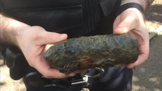 Policeman holding WW2 shell