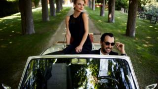 Casal em carro de luxo