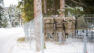 Army backpacks hang on the security fences installed by Swiss army members ahead of the upcoming World Economic Forum at Davos, Switzerland (7 January 2016)