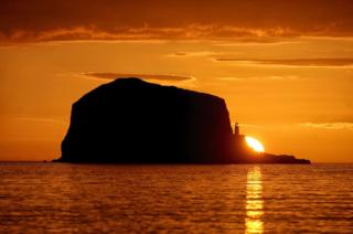 The sun rises over Bass Rock lighthouse in the Firth of Forth near North Berwick, East Lothian