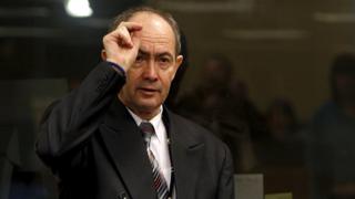 Former Bosnian Serb general Zdravko Tolimir crosses himself after arriving in the courtroom in 2010