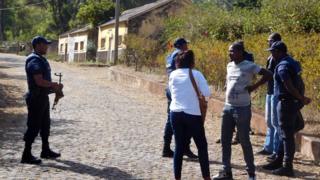 Local authorities stand near the entrance to the Monte Txota military barracks, on the island of Santiago, Cidade da Praia, Cape Verde, 26 April 2016