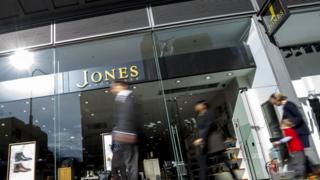 Figures walking past Jones Bootmaker shop
