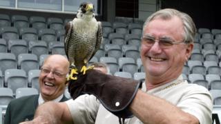 In this file photo taken on July 8, 2006, Prince consort of Denmark Henrik holds a hawk "Phoenix 2" as falconer trainer Frank Skaarup Hansen of Sonderup laughs, before the official opening ceremony of the European Hunting Horn championship held in Horsens, Jutland