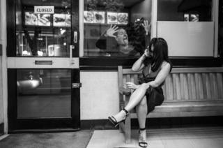A woman on the phone is surprised by a man