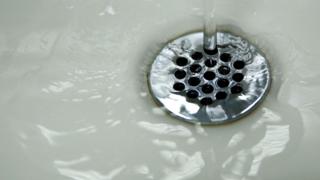 Water running down a drain in a sink