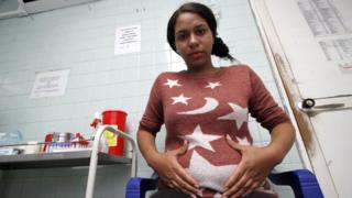 A pregnant Colombian woman, infected with the Zika virus, sits in a clinic