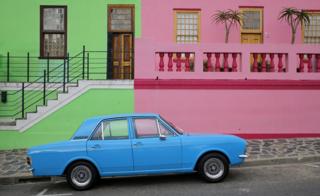 A car is parked outside colored houses of the historic Bo Kaap area of Cape Town, South Africa, 15 March 2018. This former township, situated on the slopes of Signal Hill above the city center, is a historical centre of Cape Malay culture in the city and home to the first mosque in South Africa established in 1884 by immigrant workers. The area is one of the cities biggest tourist attractions.