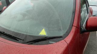 A picture of the yellow triangle on a car window to alert emergency teams to a driver's medical advice