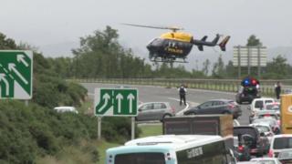 A helicopter takes off from the scene of the crash