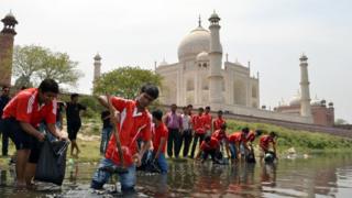 Students from the Institute of Hotel and Tourism pose as they participate in a clean-up of the Yamuna River at Dussehra Ghat behind the Taj Mahal in Agra on April 18, 2012.