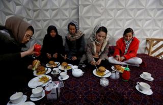 Sima Azimi (left), a trainer at the Shaolin Wushu club, eats lunch with her students at a restaurant in Kabul, Afghanistan