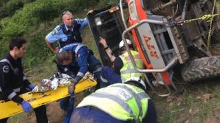 Emergency workers rescue woman trapped under a farm vehicle