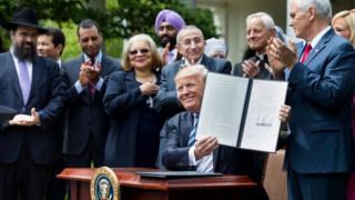 El presidente Trump muestra la orden ejecutiva firmada.